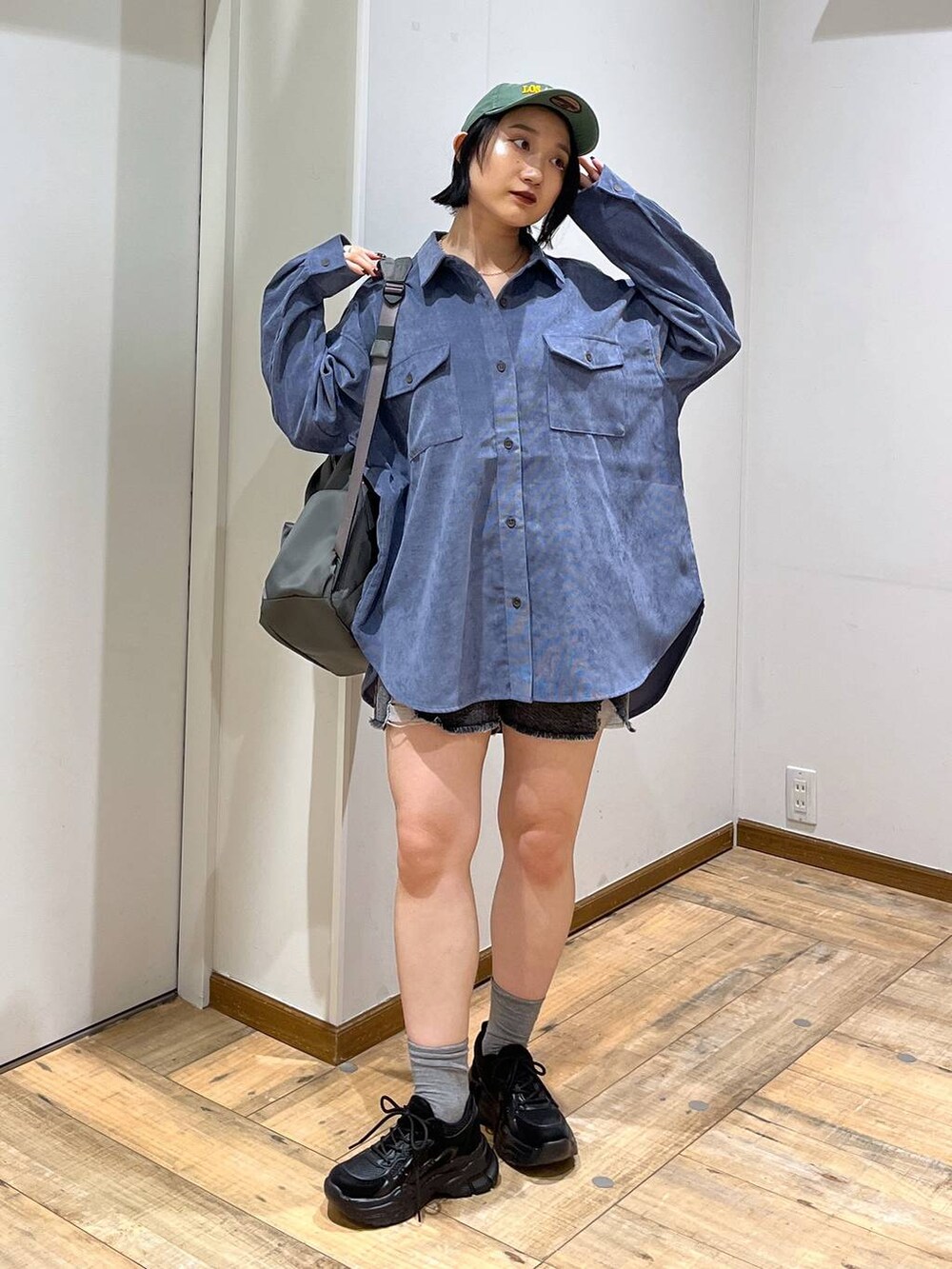 グレー系のバックパック/リュック、ブルー系のシャツ/ブラウス、ブラック系のスニーカーを着用したレディースの秋コーディネートの2枚目の写真