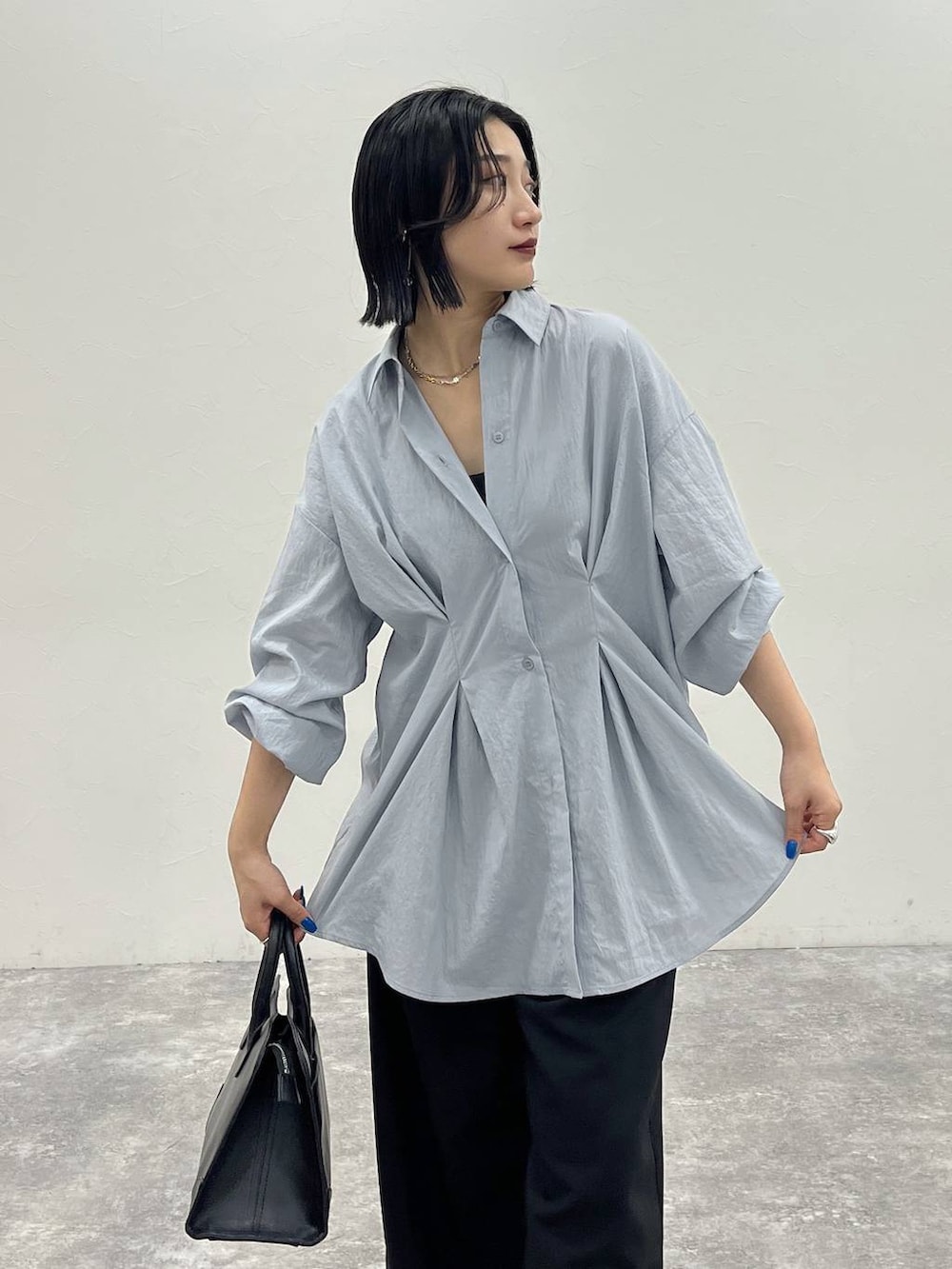 ブラック系のバレエシューズ、ブラック系のショルダーバッグ、ブルー系のシャツ/ブラウスを着用したレディースの夏コーディネートの7枚目の写真