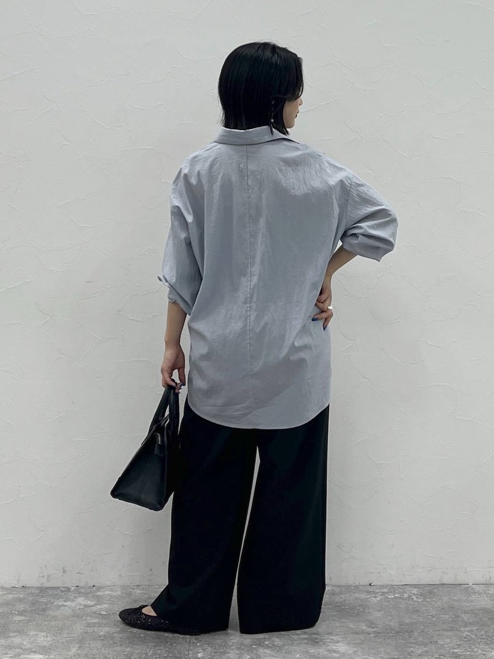 ブラック系のバレエシューズ、ブラック系のショルダーバッグ、ブルー系のシャツ/ブラウスを着用したレディースの夏コーディネートの6枚目の写真