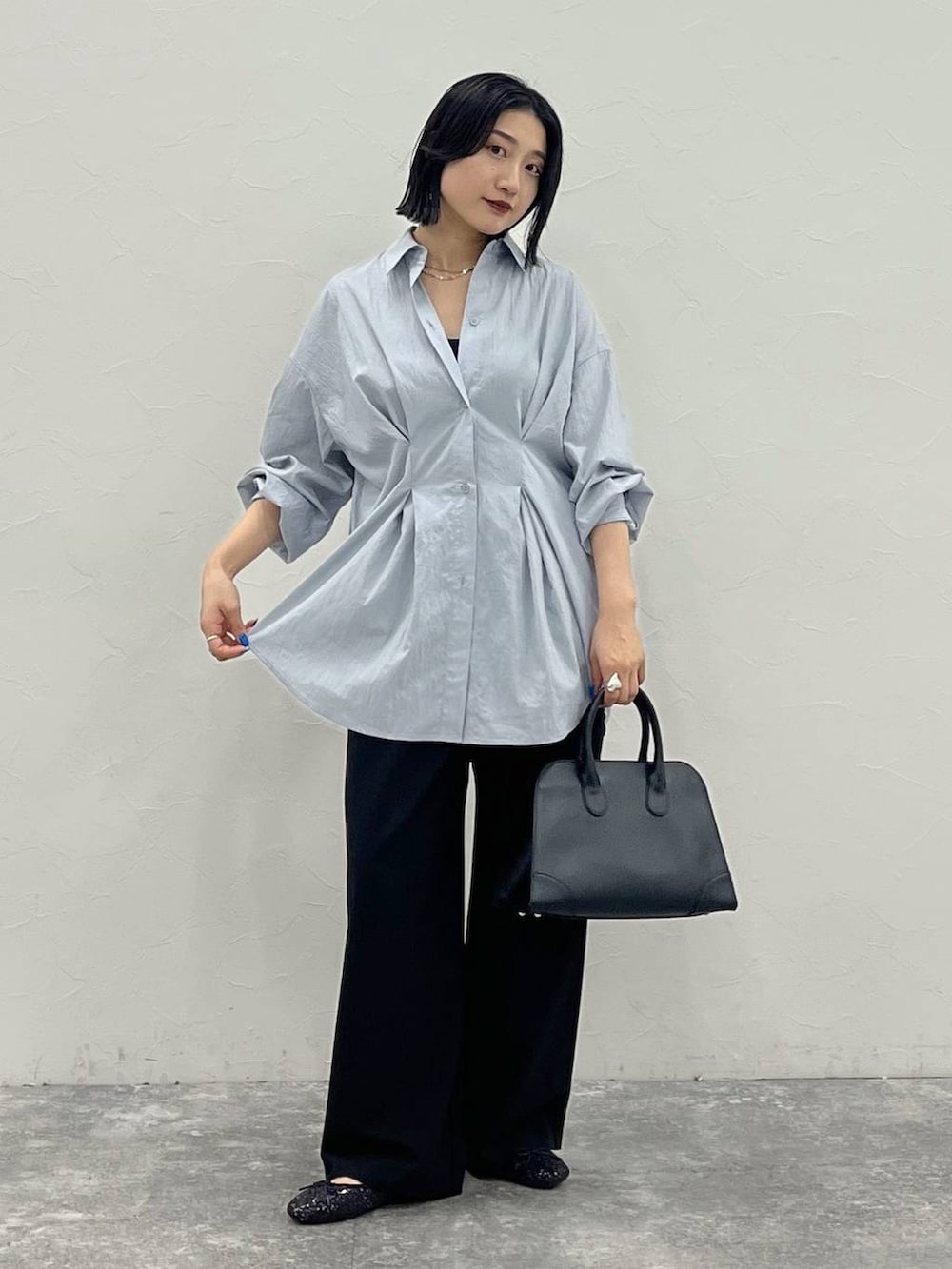 ブラック系のバレエシューズ、ブラック系のショルダーバッグ、ブルー系のシャツ/ブラウスを着用したレディースの夏コーディネートの2枚目の写真