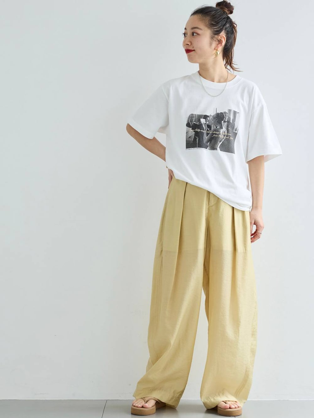 ベージュ系のその他パンツ、ホワイト系のTシャツ/カットソー、ゴールド系のバングル/リストバンドを着用したレディースの春コーディネートの2枚目の写真