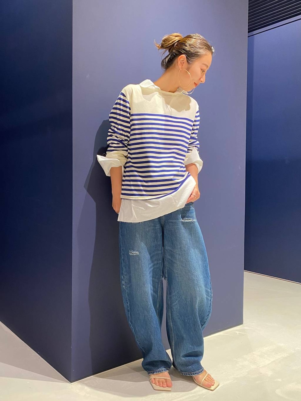 ブルー系のデニムパンツ、ホワイト系のシャツ/ブラウス、ホワイト系のニット/セーターを着用したレディースの夏コーディネートの2枚目の写真