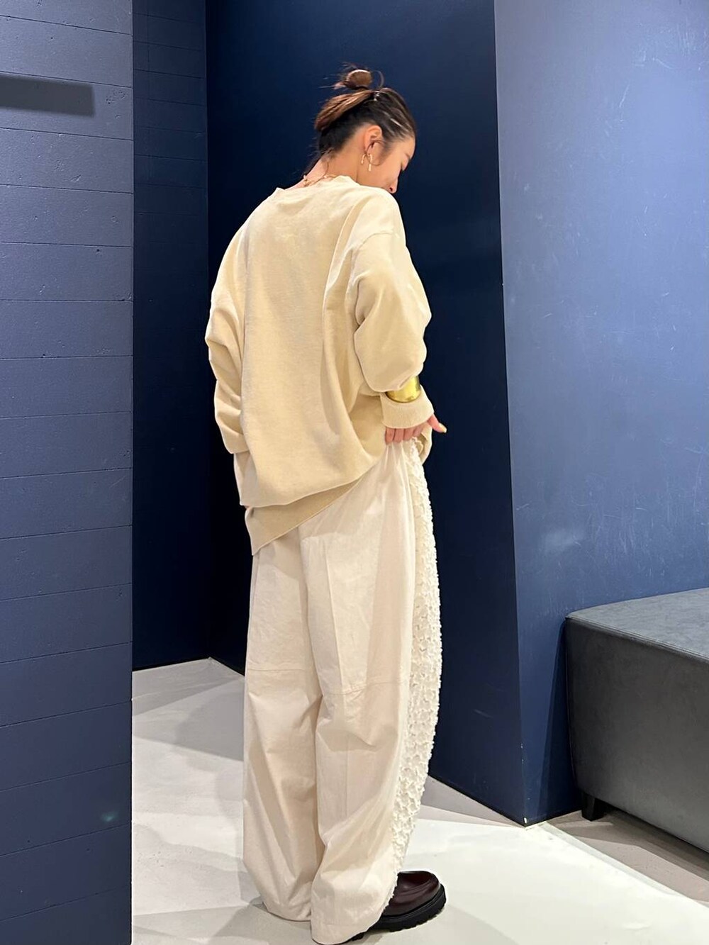 ホワイト系のその他パンツ、ホワイト系のニット/セーター、ゴールド系のバングル/リストバンドを着用したレディースの夏コーディネートの6枚目の写真