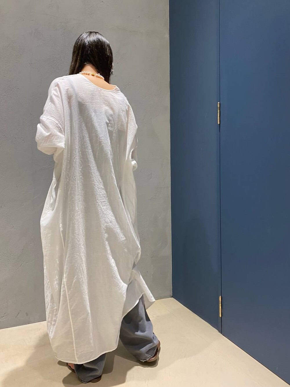 グレー系のデニムパンツ、ホワイト系のワンピースを着用したレディースの夏コーディネートの4枚目の写真