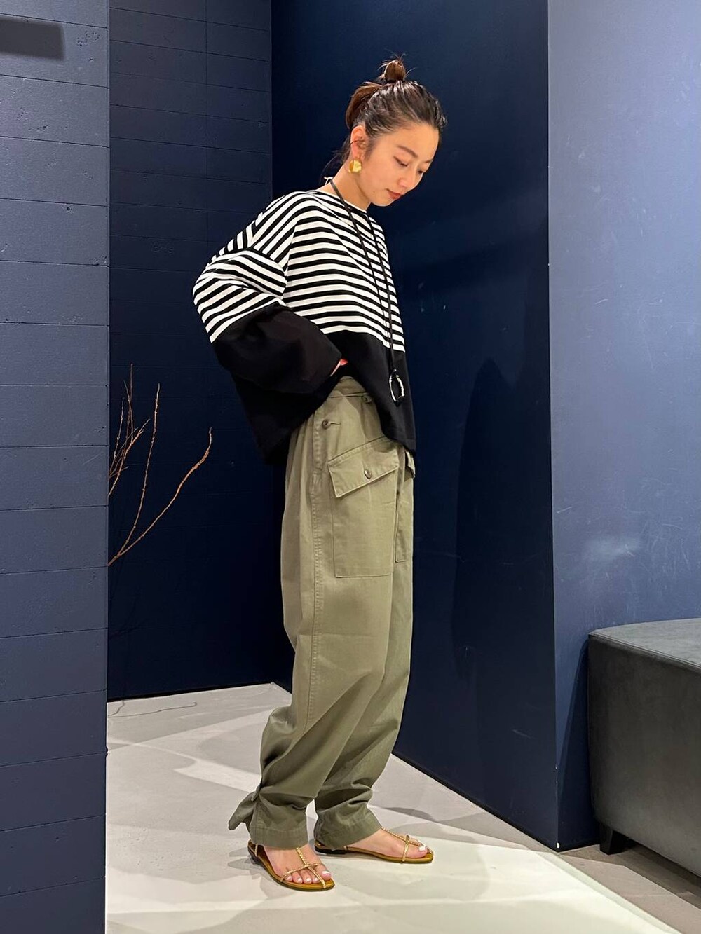 グリーン系のカーゴパンツ、ブラック系のニット/セーター、ブラック系のネックレスを着用したレディースの夏コーディネートの2枚目の写真