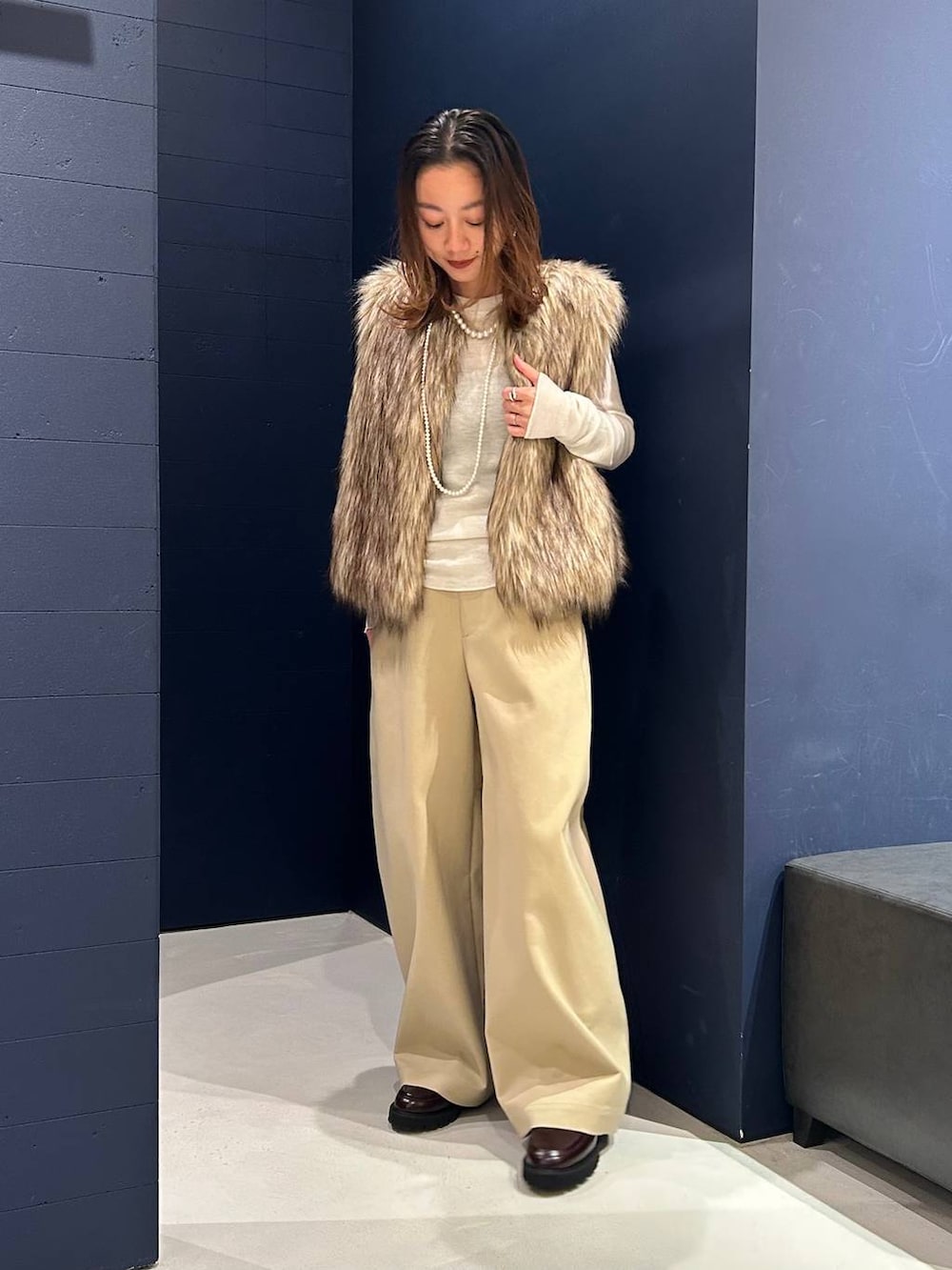 ブラウン系のその他パンツ、ベージュ系のベスト、ホワイト系のニット/セーターを着用したレディースの秋コーディネートの2枚目の写真