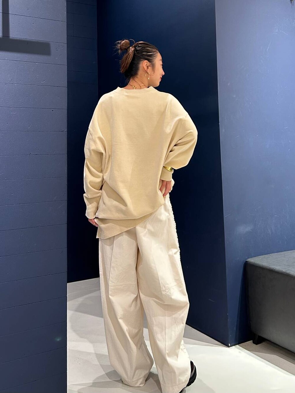 ホワイト系のその他パンツ、ホワイト系のニット/セーター、ゴールド系のバングル/リストバンドを着用したレディースの夏コーディネートの4枚目の写真