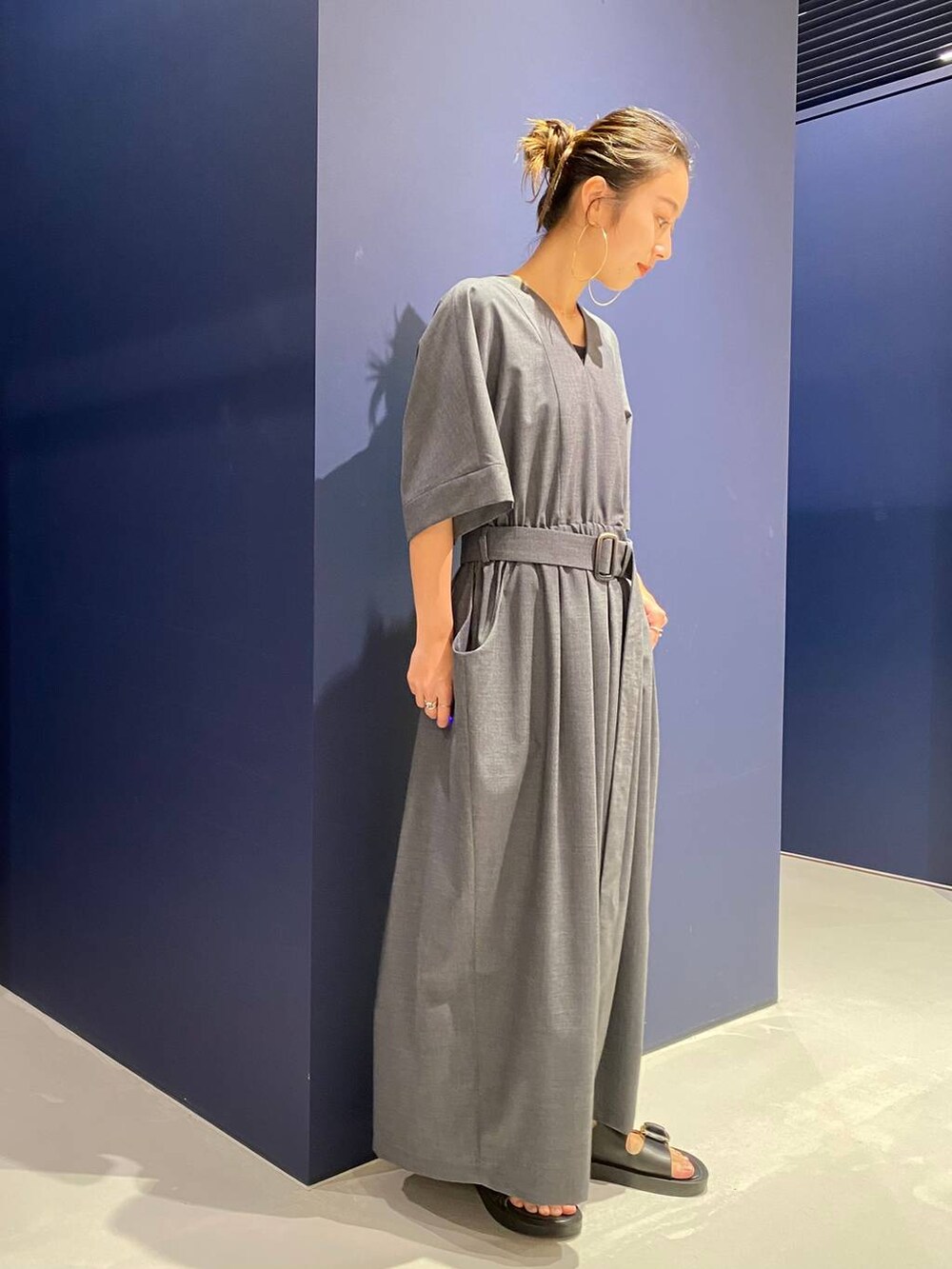 ブラック系のサンダル、グレー系のワンピースを着用したレディースの夏コーディネートの3枚目の写真