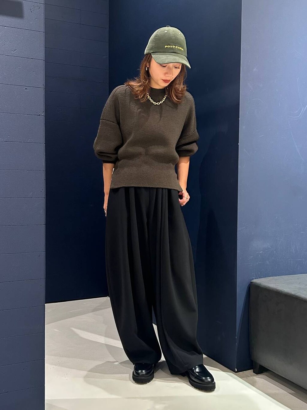 ブラック系のその他パンツ、グリーン系のニット/セーター、ゴールド系のネックレスを着用したレディースの秋コーディネートの2枚目の写真