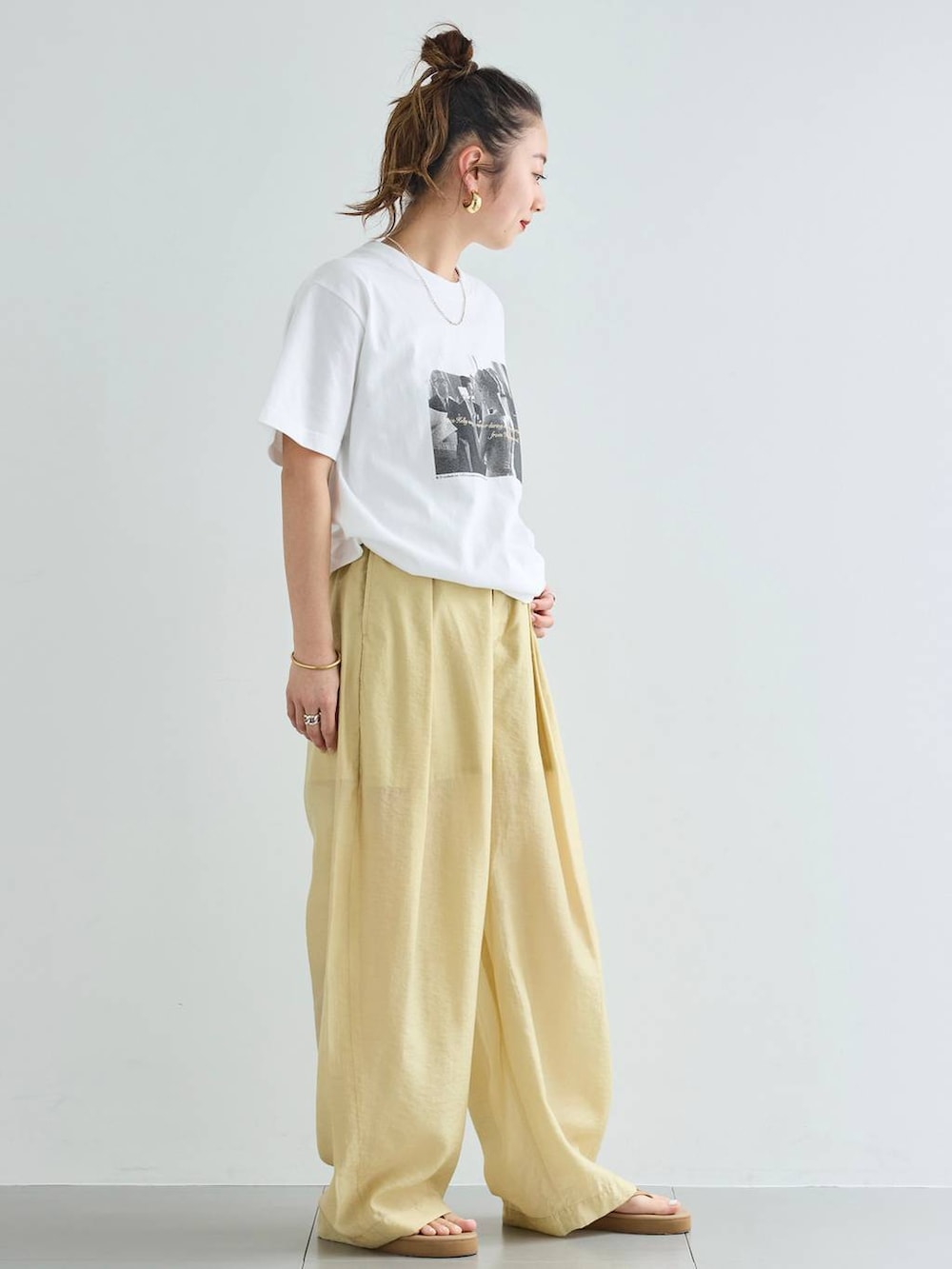 ベージュ系のその他パンツ、ホワイト系のTシャツ/カットソー、ゴールド系のバングル/リストバンドを着用したレディースの春コーディネートの4枚目の写真