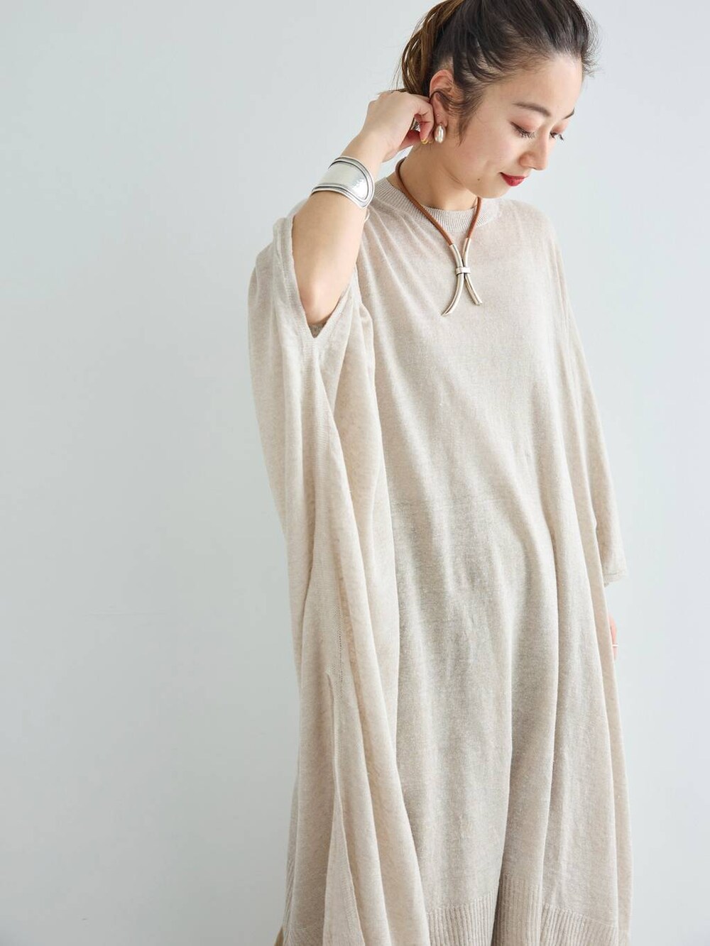 ベージュ系のその他パンツ、グレー系のニット/セーター、シルバー系のピアス(両耳用)を着用したレディースの夏コーディネートの5枚目の写真