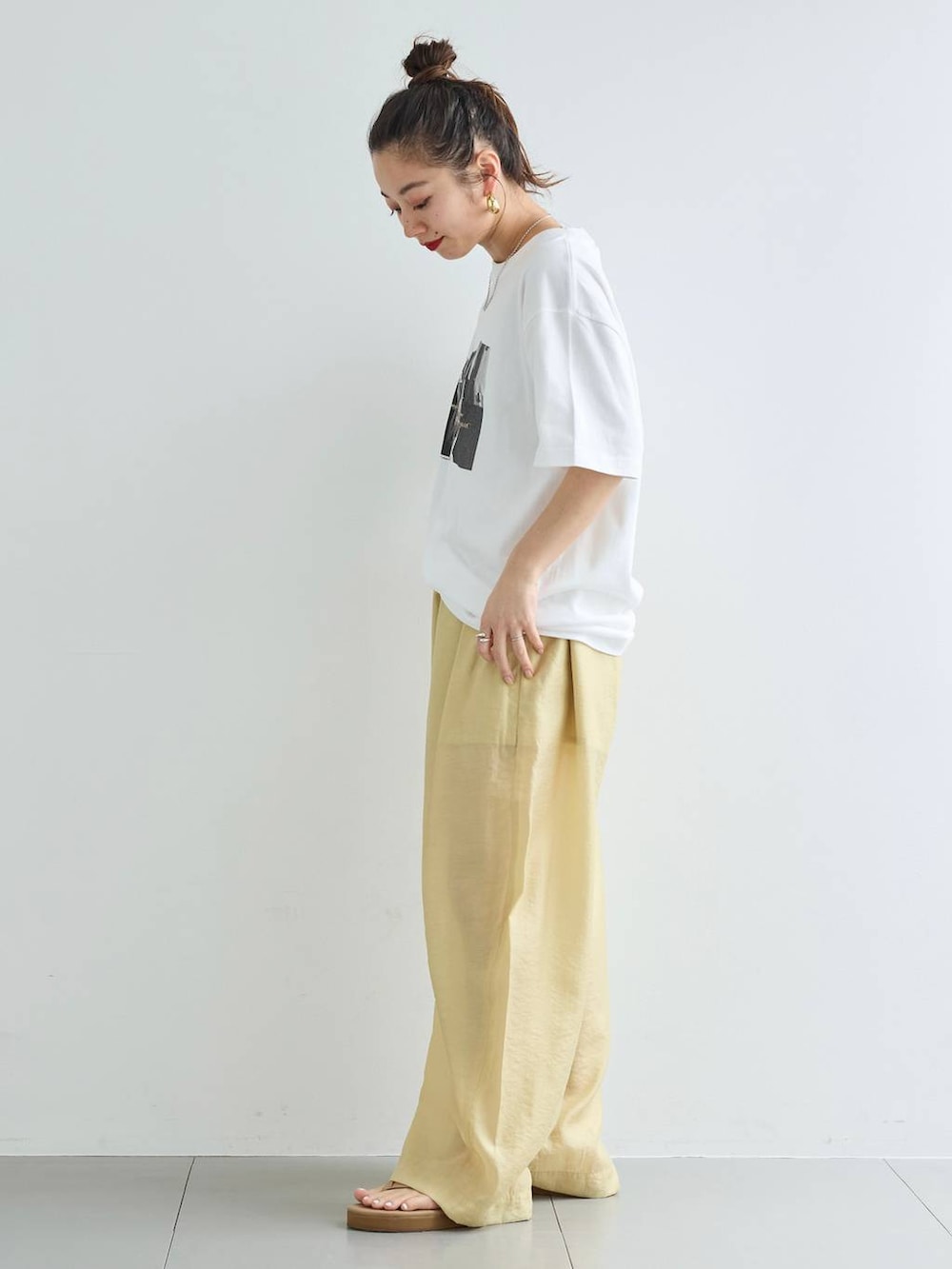 ベージュ系のその他パンツ、ホワイト系のTシャツ/カットソー、ゴールド系のバングル/リストバンドを着用したレディースの春コーディネートの3枚目の写真