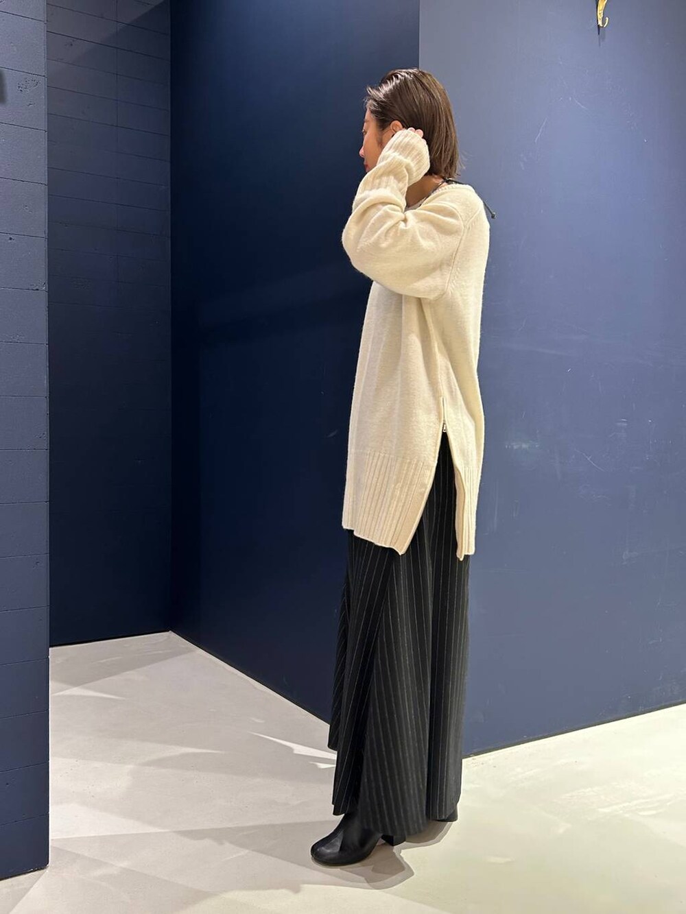 ホワイト系のニット/セーター、グレー系のスカートを着用したレディースの冬コーディネートの5枚目の写真