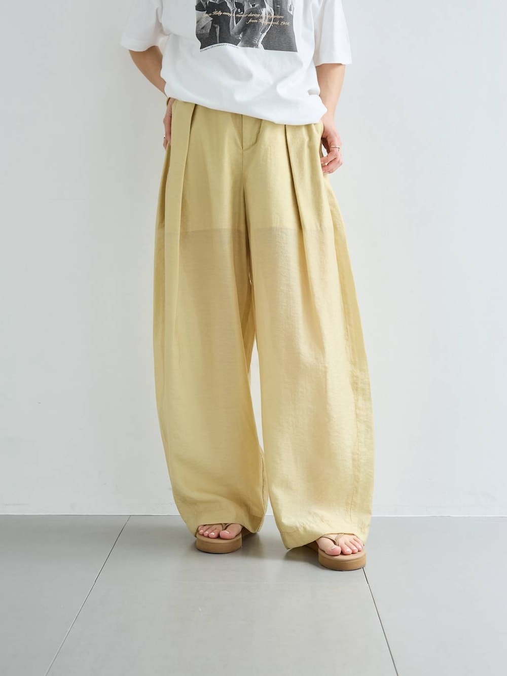 ベージュ系のその他パンツ、ホワイト系のTシャツ/カットソー、ゴールド系のバングル/リストバンドを着用したレディースの春コーディネートの8枚目の写真