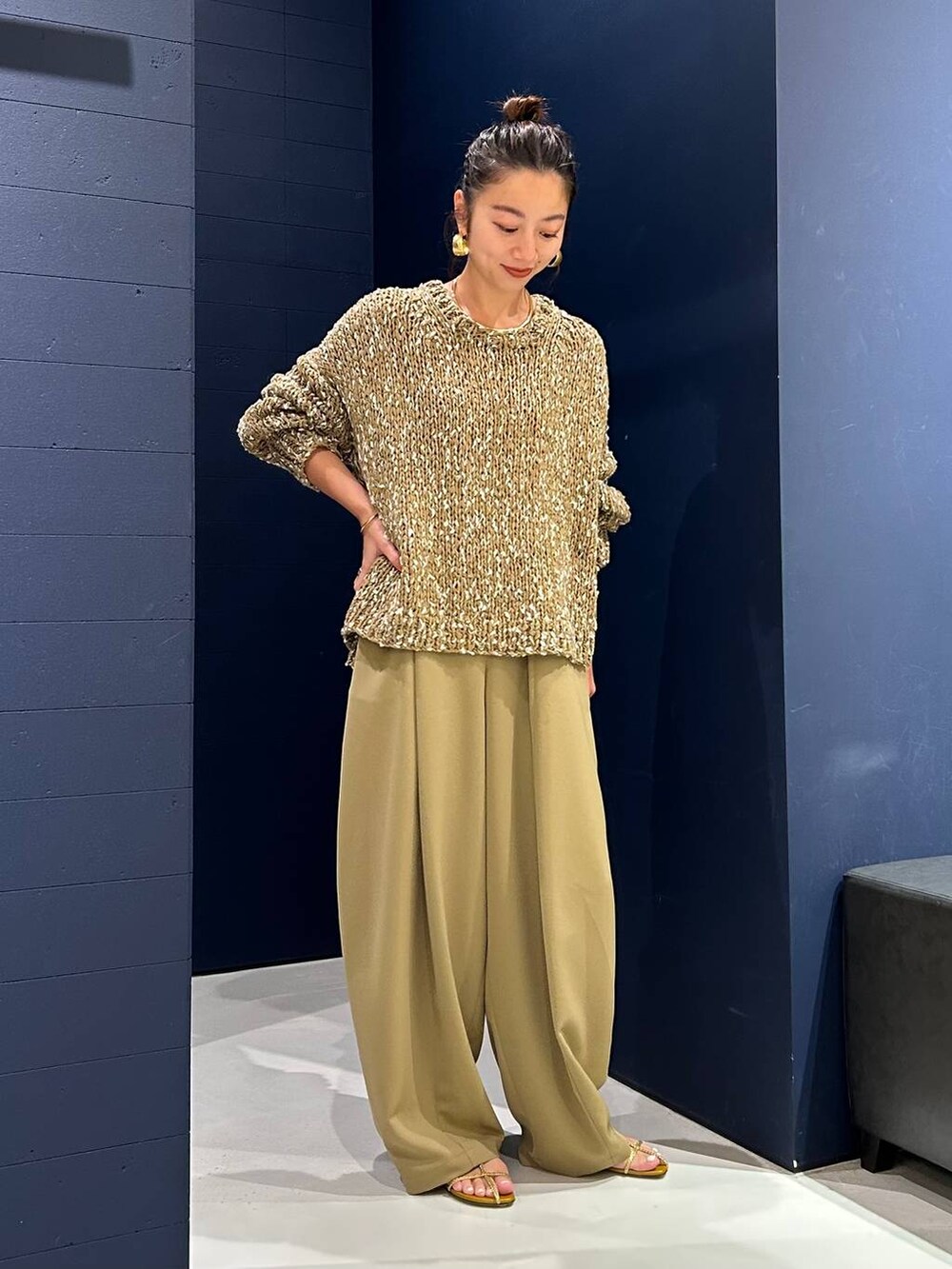 イエロー系のその他パンツ、ベージュ系のニット/セーター、ゴールド系のバングル/リストバンドを着用したレディースの夏コーディネートの2枚目の写真