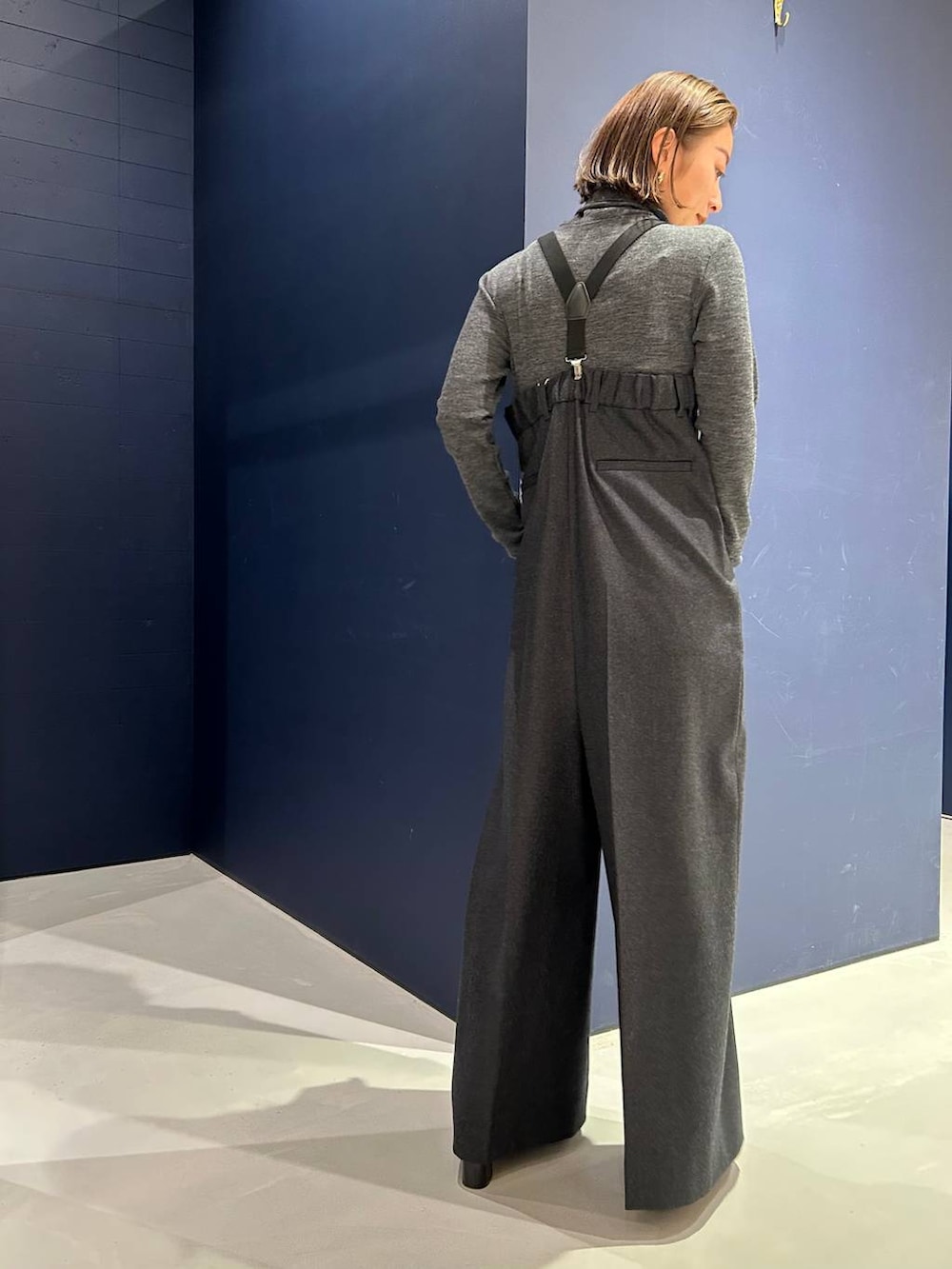 グレー系のサロペット/オーバーオール、グレー系のニット/セーター、ゴールド系のチョーカーを着用したレディースの冬コーディネートの4枚目の写真