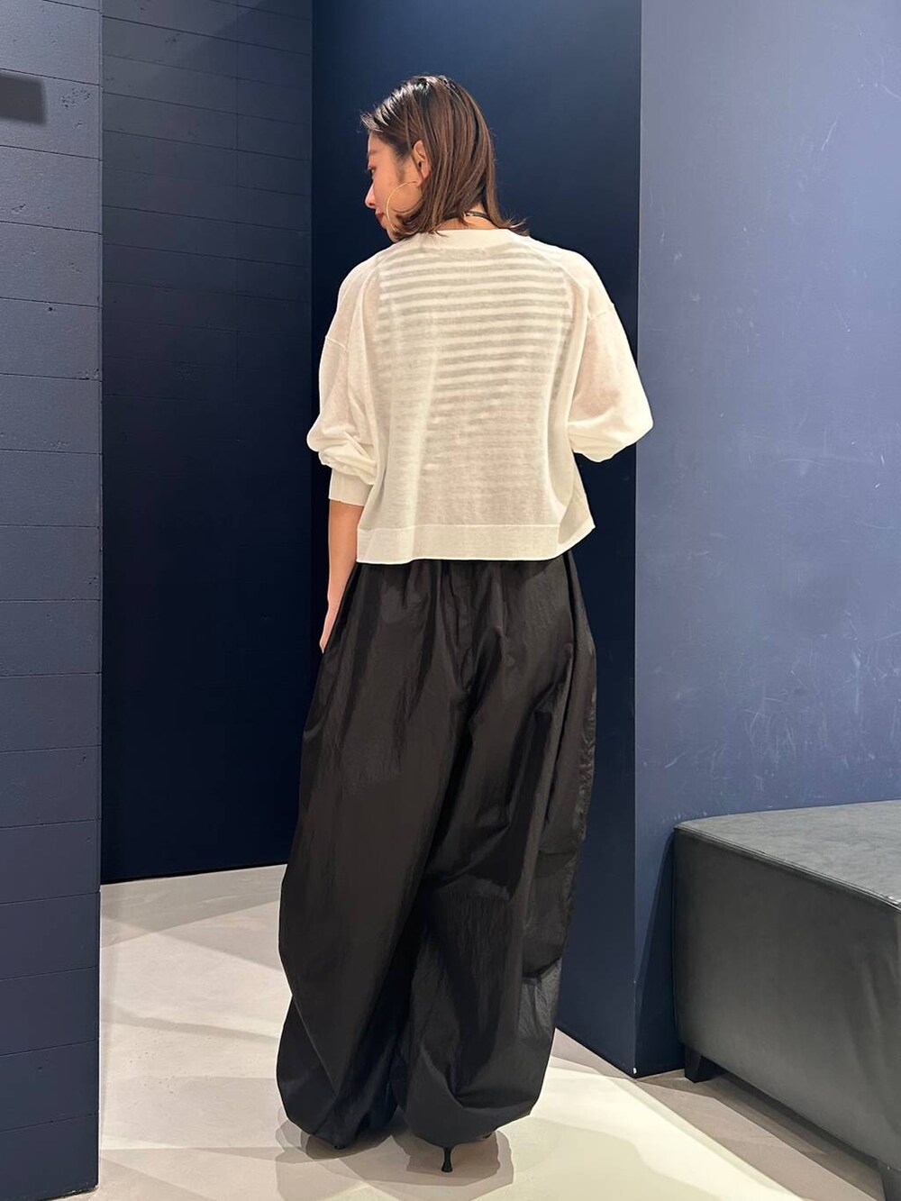 ホワイト系のカーディガン/ボレロ、ブラック系のタンクトップ、ブラック系のカーゴパンツを着用したレディースの春コーディネートの4枚目の写真