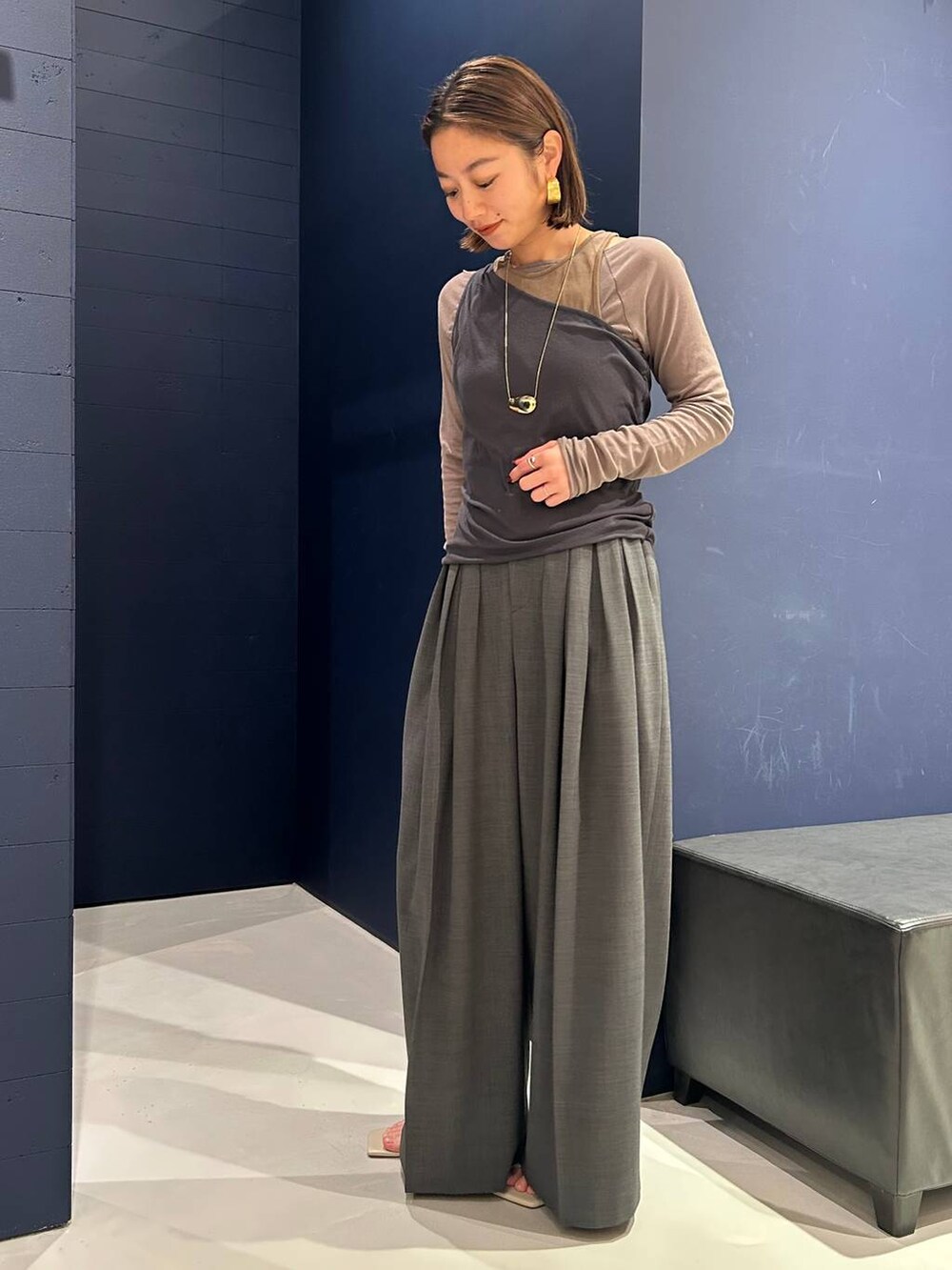 グレー系のその他パンツ、グレー系のTシャツ/カットソー、ブラウン系のタンクトップを着用したレディースの春コーディネートの3枚目の写真