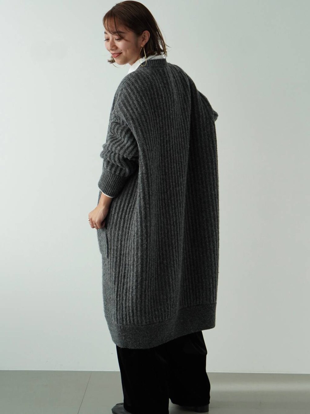 グレー系のカーディガン/ボレロ、ホワイト系のシャツ/ブラウス、ブラック系のその他パンツを着用したレディースの秋コーディネートの2枚目の写真