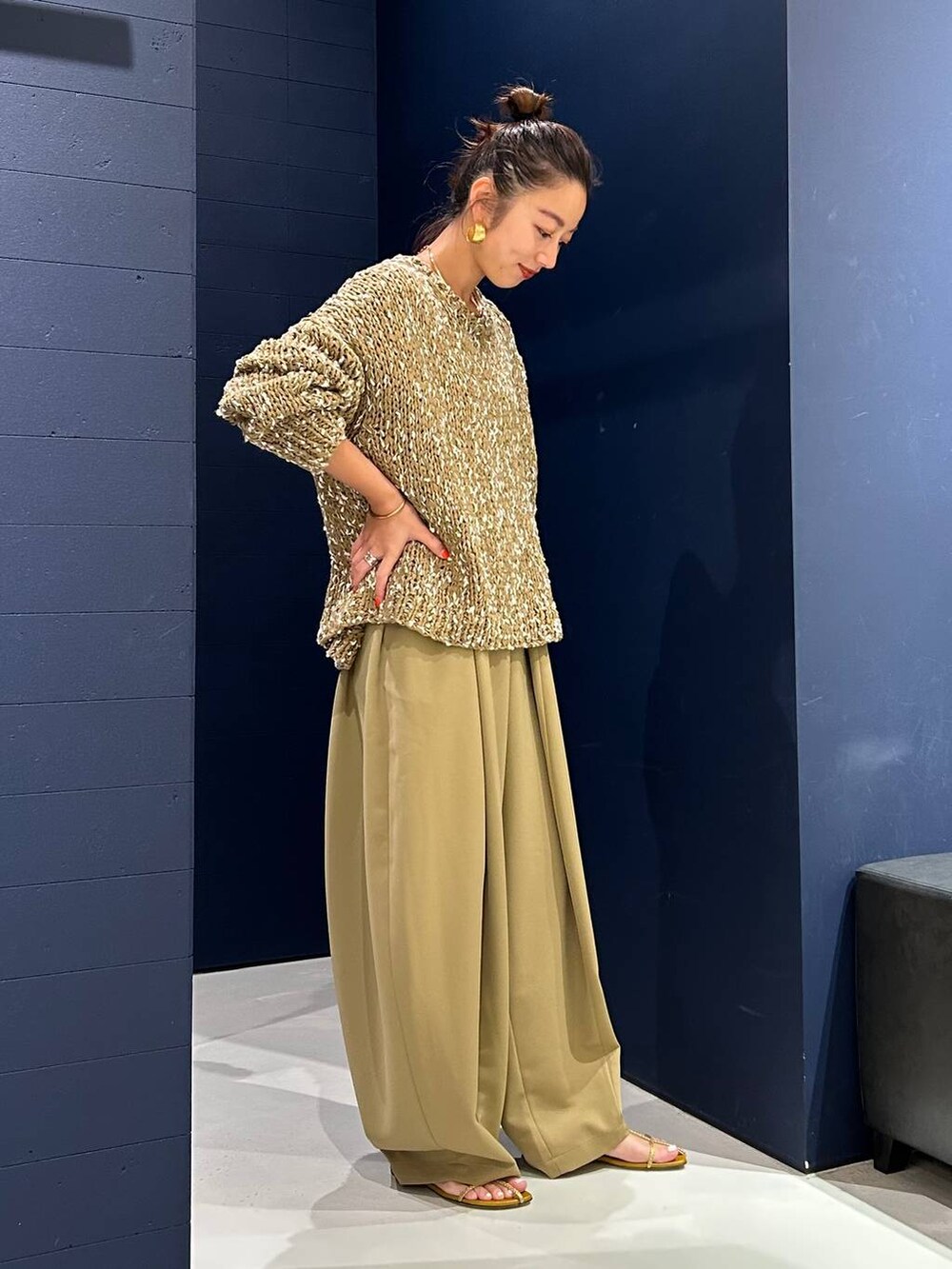 イエロー系のその他パンツ、ベージュ系のニット/セーター、ゴールド系のバングル/リストバンドを着用したレディースの夏コーディネートの5枚目の写真