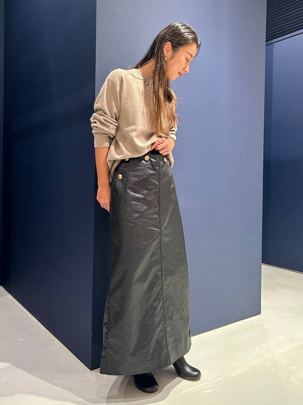 ベージュ系のTシャツ/カットソー、ブラック系のスカートを着用したレディースの秋コーディネートの3枚目の写真