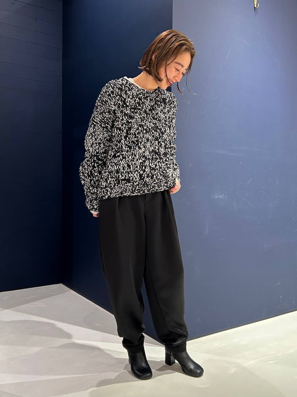 ブラック系のその他パンツ、ホワイト系のニット/セーター、ブラック系のニット/セーターを着用したレディースの冬コーディネートの4枚目の写真
