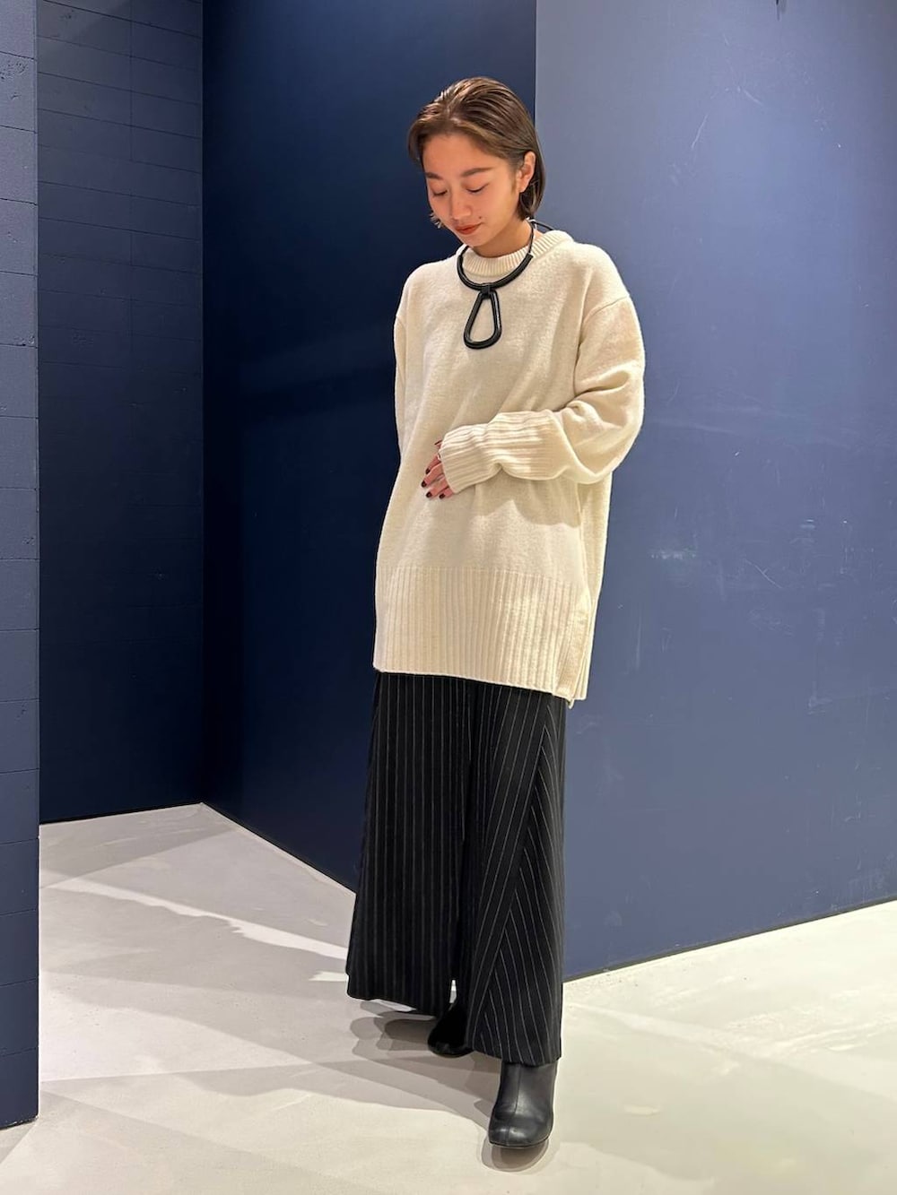 ホワイト系のニット/セーター、グレー系のスカートを着用したレディースの冬コーディネートの3枚目の写真