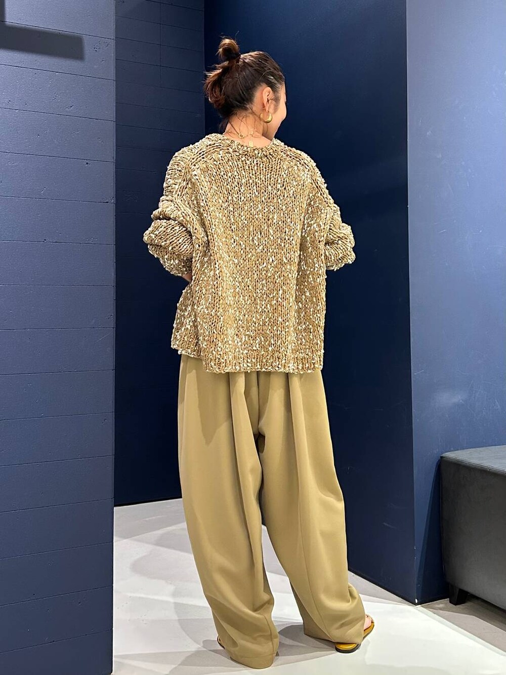 イエロー系のその他パンツ、ベージュ系のニット/セーター、ゴールド系のバングル/リストバンドを着用したレディースの夏コーディネートの4枚目の写真