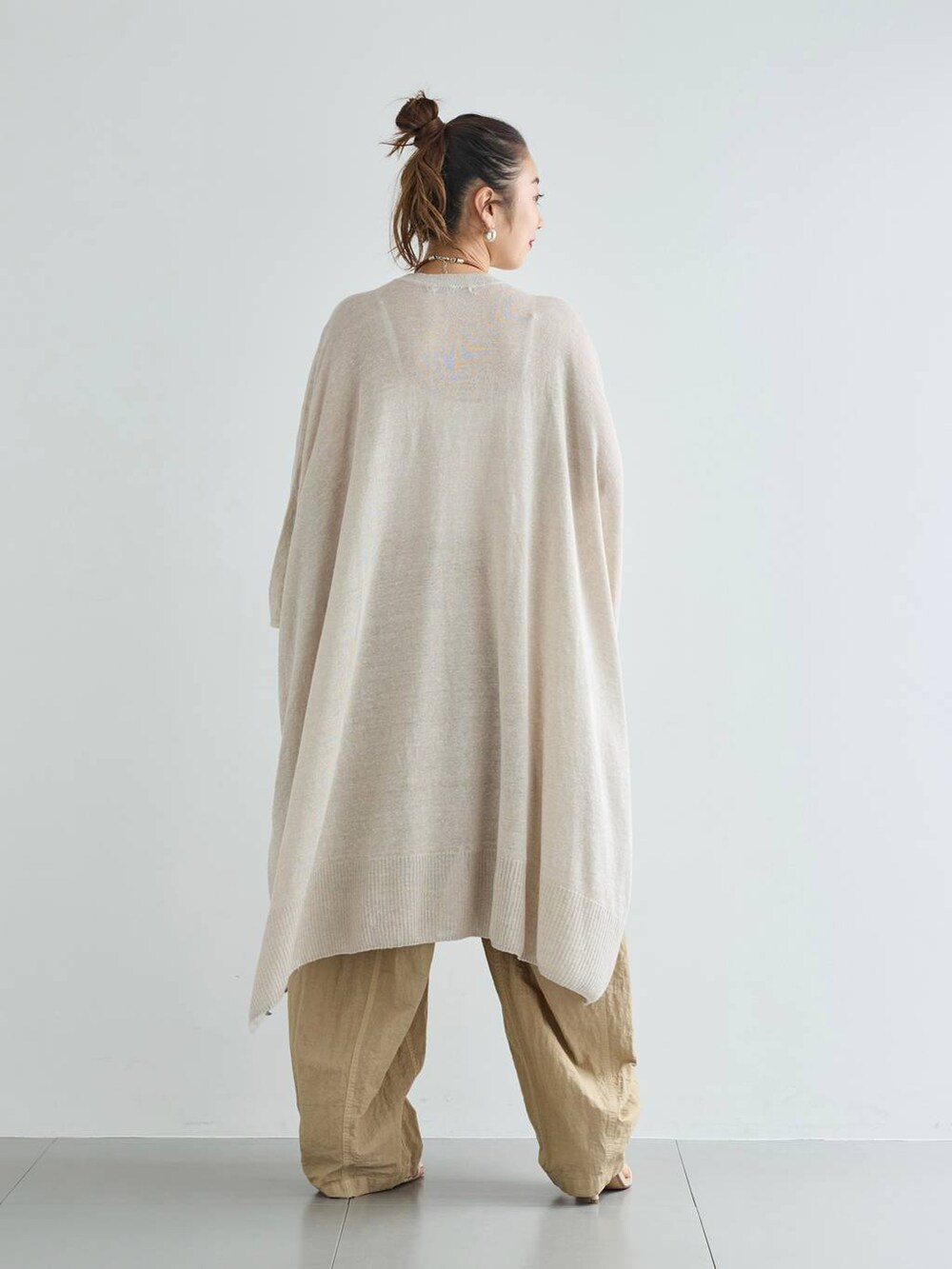 ベージュ系のその他パンツ、グレー系のニット/セーター、シルバー系のピアス(両耳用)を着用したレディースの夏コーディネートの3枚目の写真