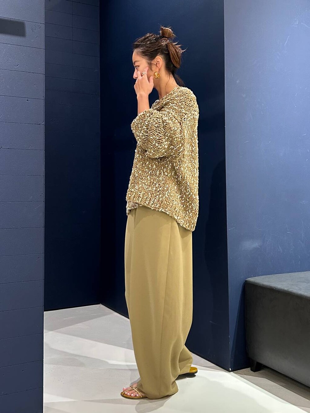 イエロー系のその他パンツ、ベージュ系のニット/セーター、ゴールド系のバングル/リストバンドを着用したレディースの夏コーディネートの3枚目の写真