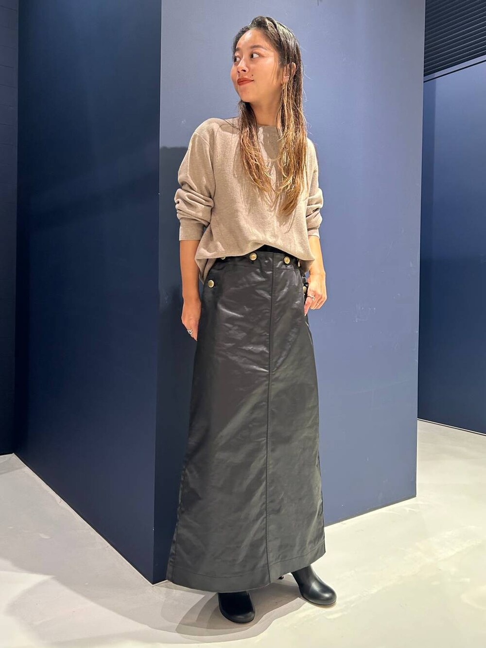 ベージュ系のTシャツ/カットソー、ブラック系のスカートを着用したレディースの秋コーディネートの2枚目の写真