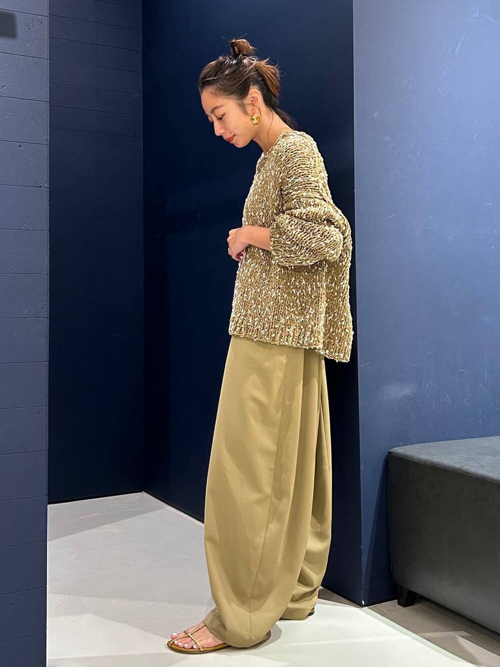 イエロー系のその他パンツ、ベージュ系のニット/セーター、ゴールド系のバングル/リストバンドを着用したレディースの夏コーディネートの6枚目の写真