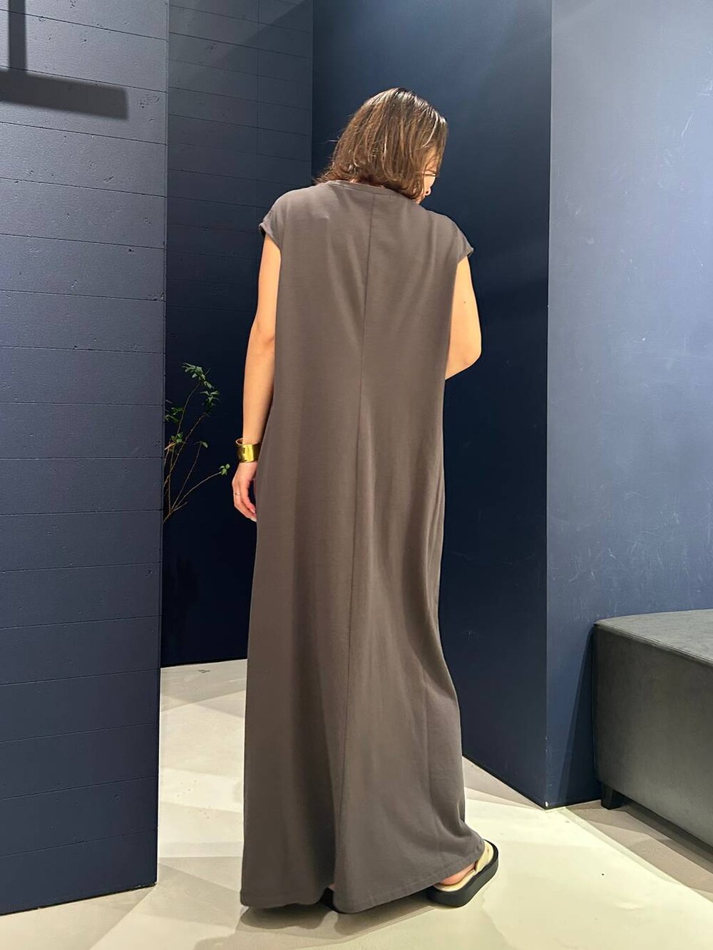 グレー系のワンピース、ゴールド系のバングル/リストバンド、ゴールド系のネックレスを着用したレディースの夏コーディネートの3枚目の写真