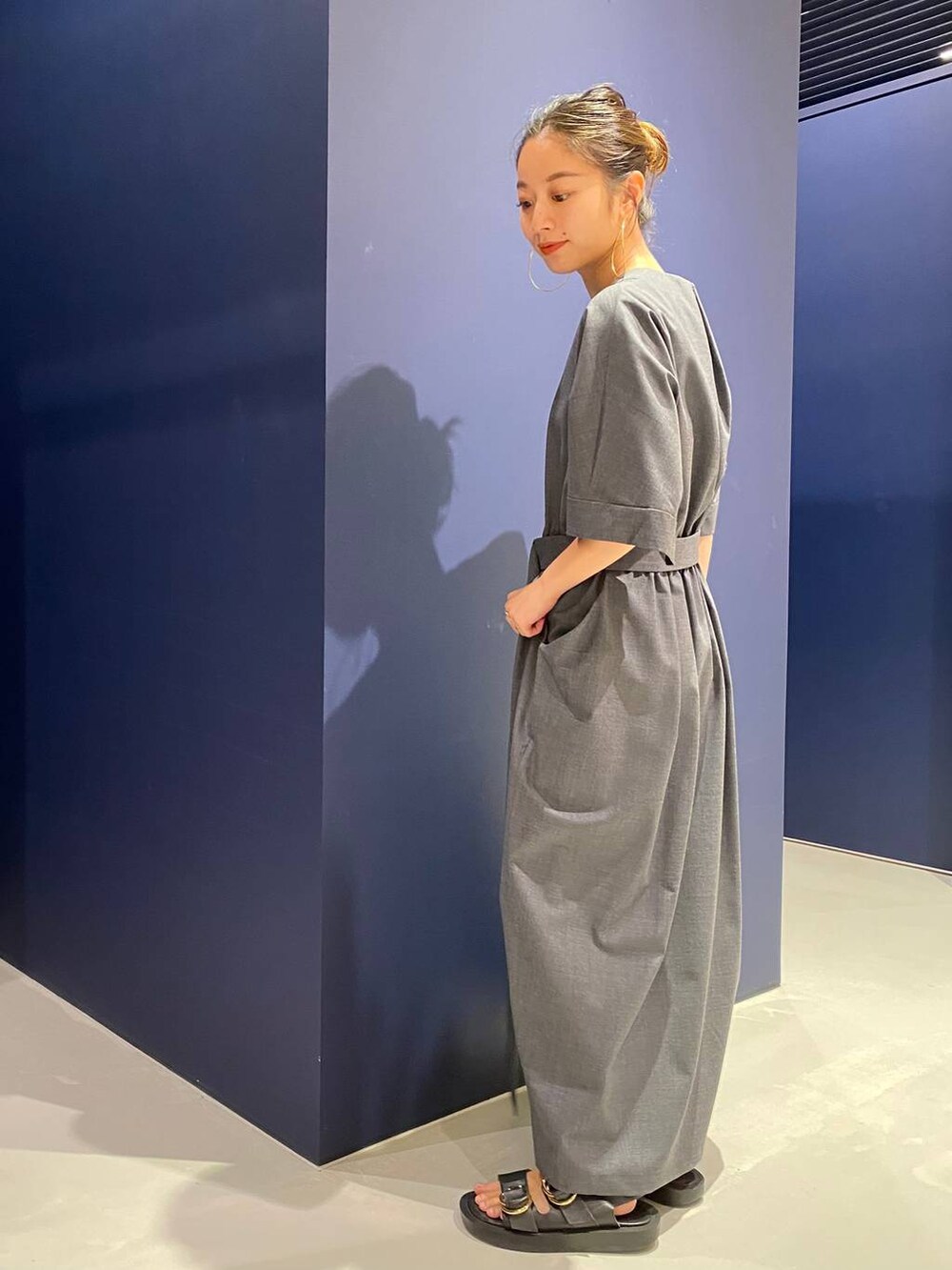 ブラック系のサンダル、グレー系のワンピースを着用したレディースの夏コーディネートの2枚目の写真