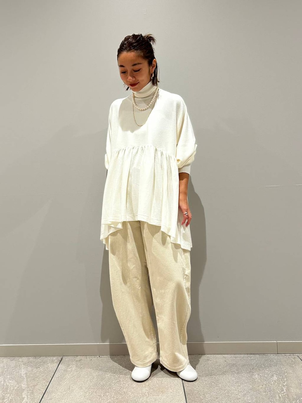 ホワイト系のニット/セーター、ホワイト系のその他パンツ、ゴールド系のネックレスを着用したレディースの秋コーディネートの2枚目の写真