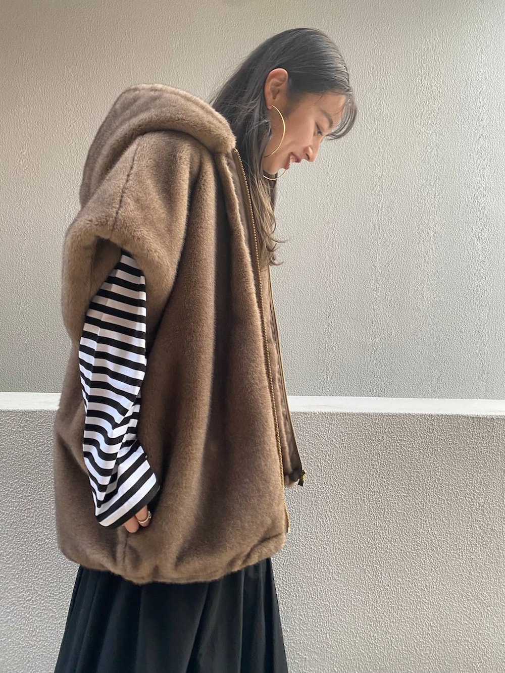 ブラウン系のベスト、ブラック系のTシャツ/カットソー、ブラック系のスカートを着用したレディースの秋コーディネートの5枚目の写真