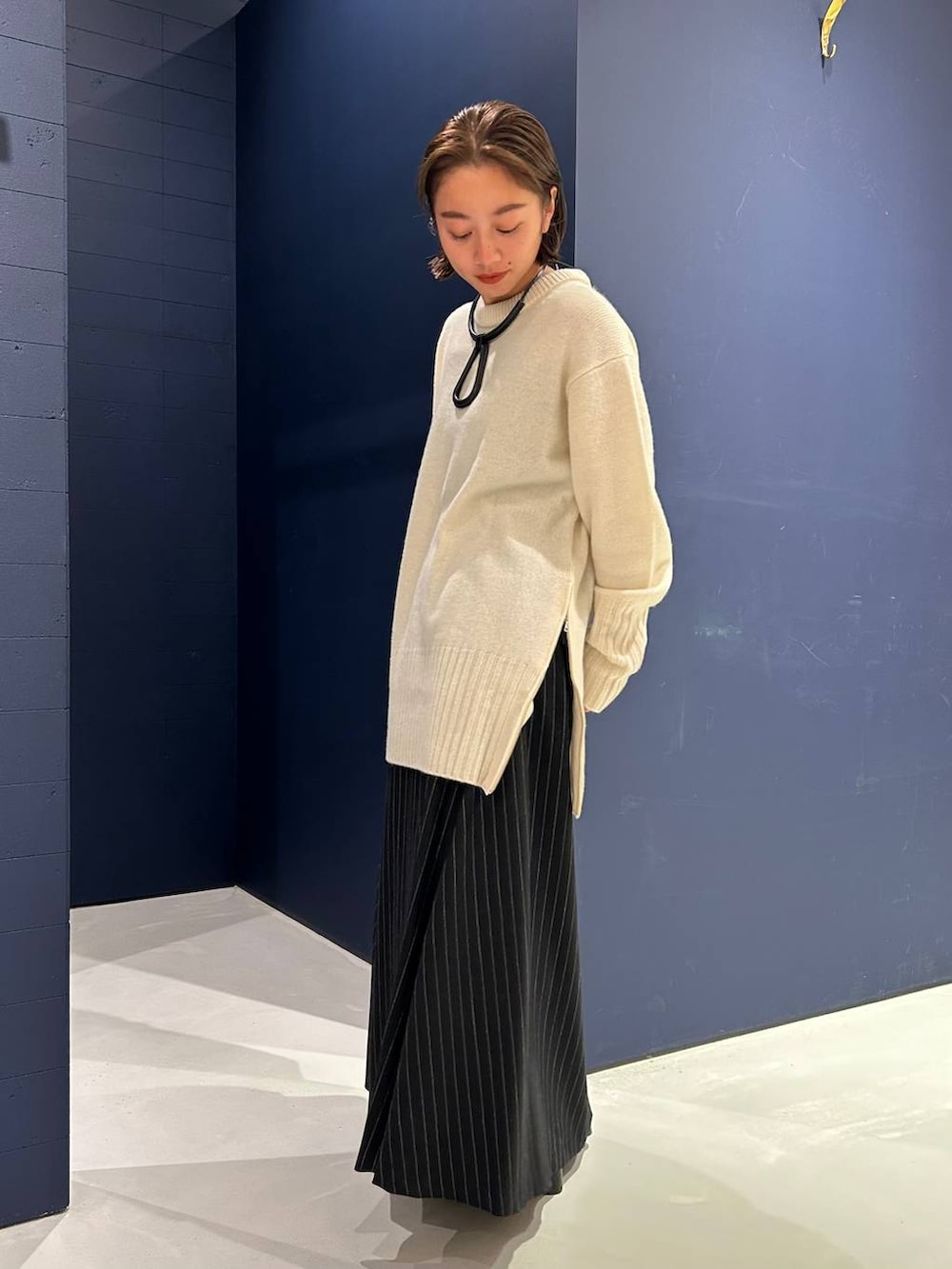 ホワイト系のニット/セーター、グレー系のスカートを着用したレディースの冬コーディネートの4枚目の写真