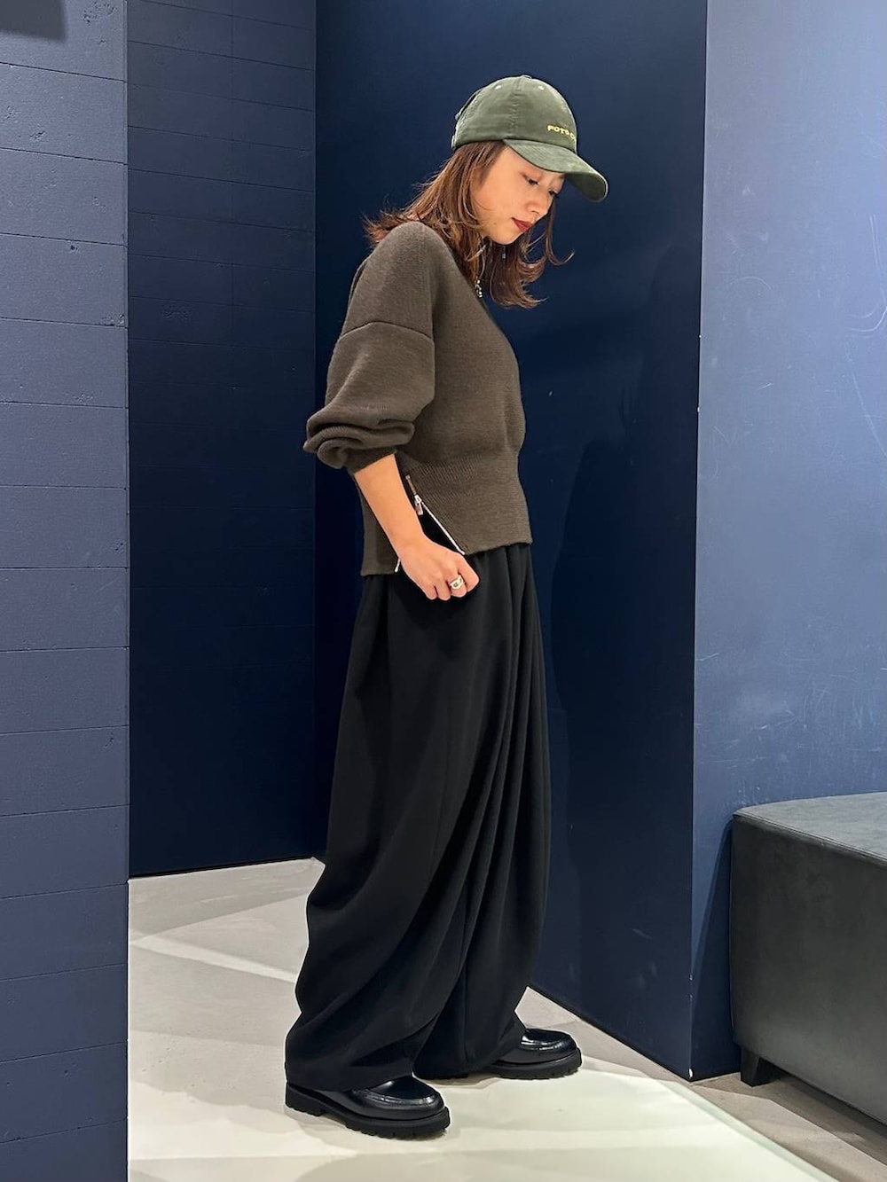 ブラック系のその他パンツ、グリーン系のニット/セーター、ゴールド系のネックレスを着用したレディースの秋コーディネートの5枚目の写真