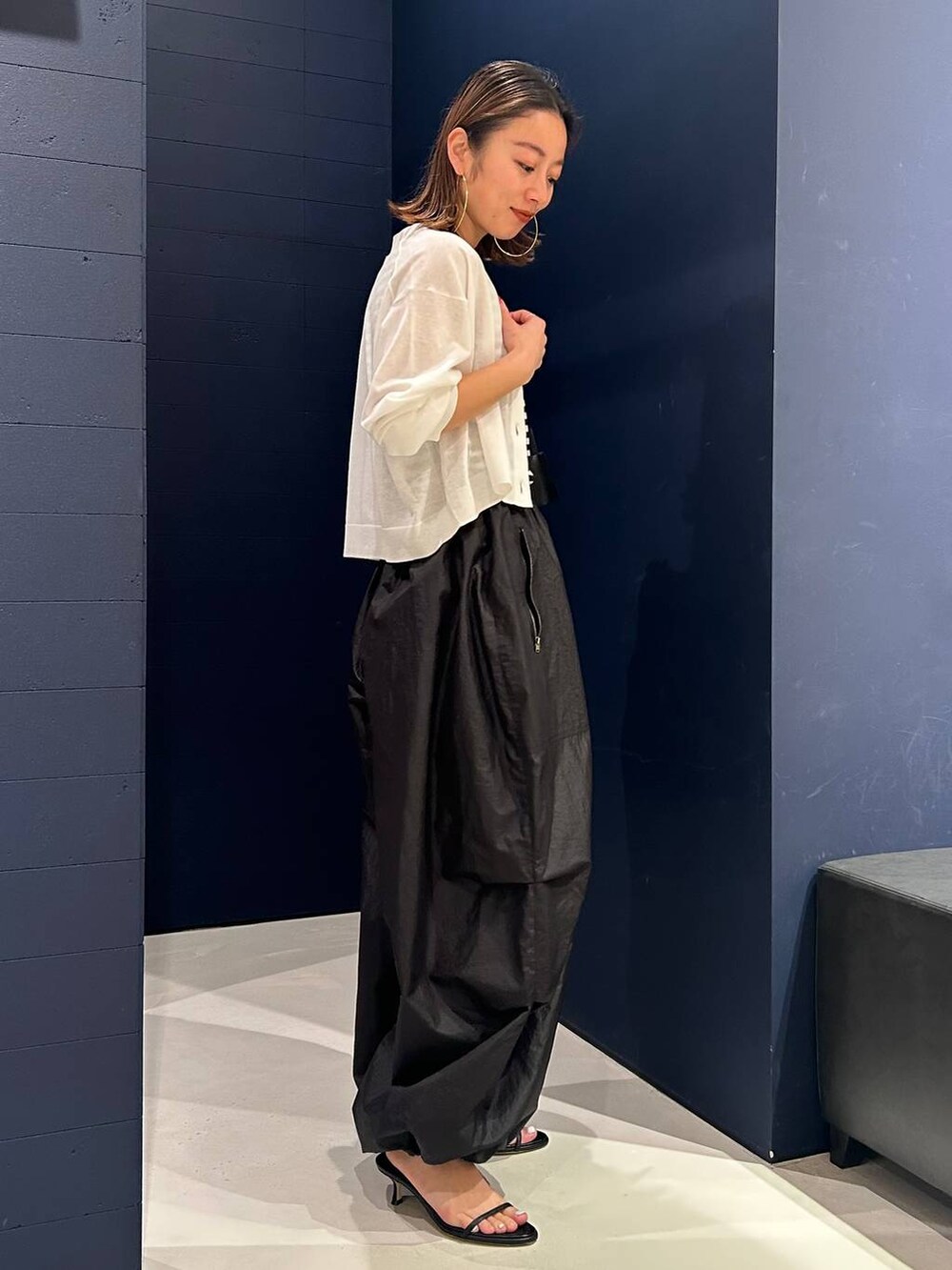 ホワイト系のカーディガン/ボレロ、ブラック系のタンクトップ、ブラック系のカーゴパンツを着用したレディースの春コーディネートの3枚目の写真