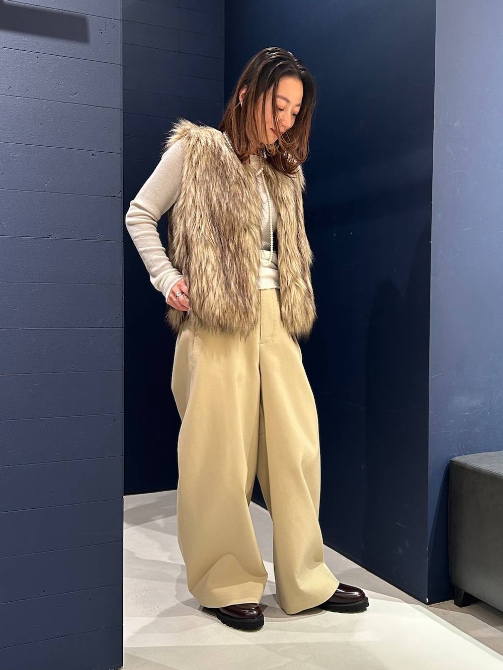 ブラウン系のその他パンツ、ベージュ系のベスト、ホワイト系のニット/セーターを着用したレディースの秋コーディネートの4枚目の写真