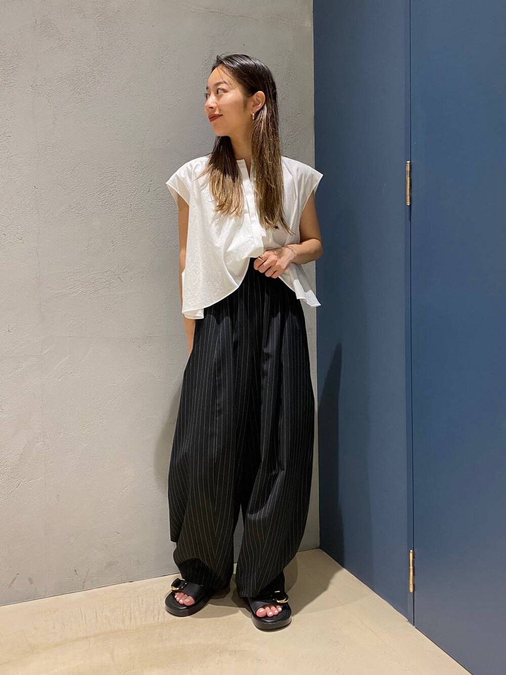 ブラック系のサンダル、ホワイト系のシャツ/ブラウス、ブラック系のその他パンツを着用したレディースの夏コーディネートの2枚目の写真