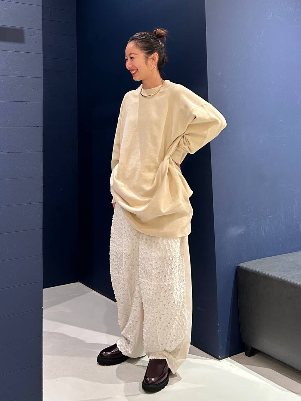 ホワイト系のその他パンツ、ホワイト系のニット/セーター、ゴールド系のバングル/リストバンドを着用したレディースの夏コーディネートの2枚目の写真