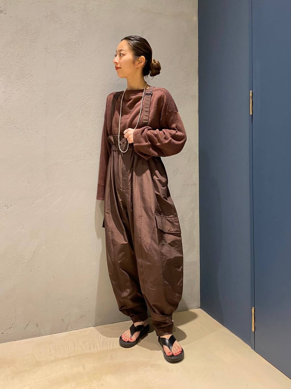 ブラウン系のニット/セーター、ブラウン系のサロペット/オーバーオールを着用したレディースの夏コーディネートの3枚目の写真