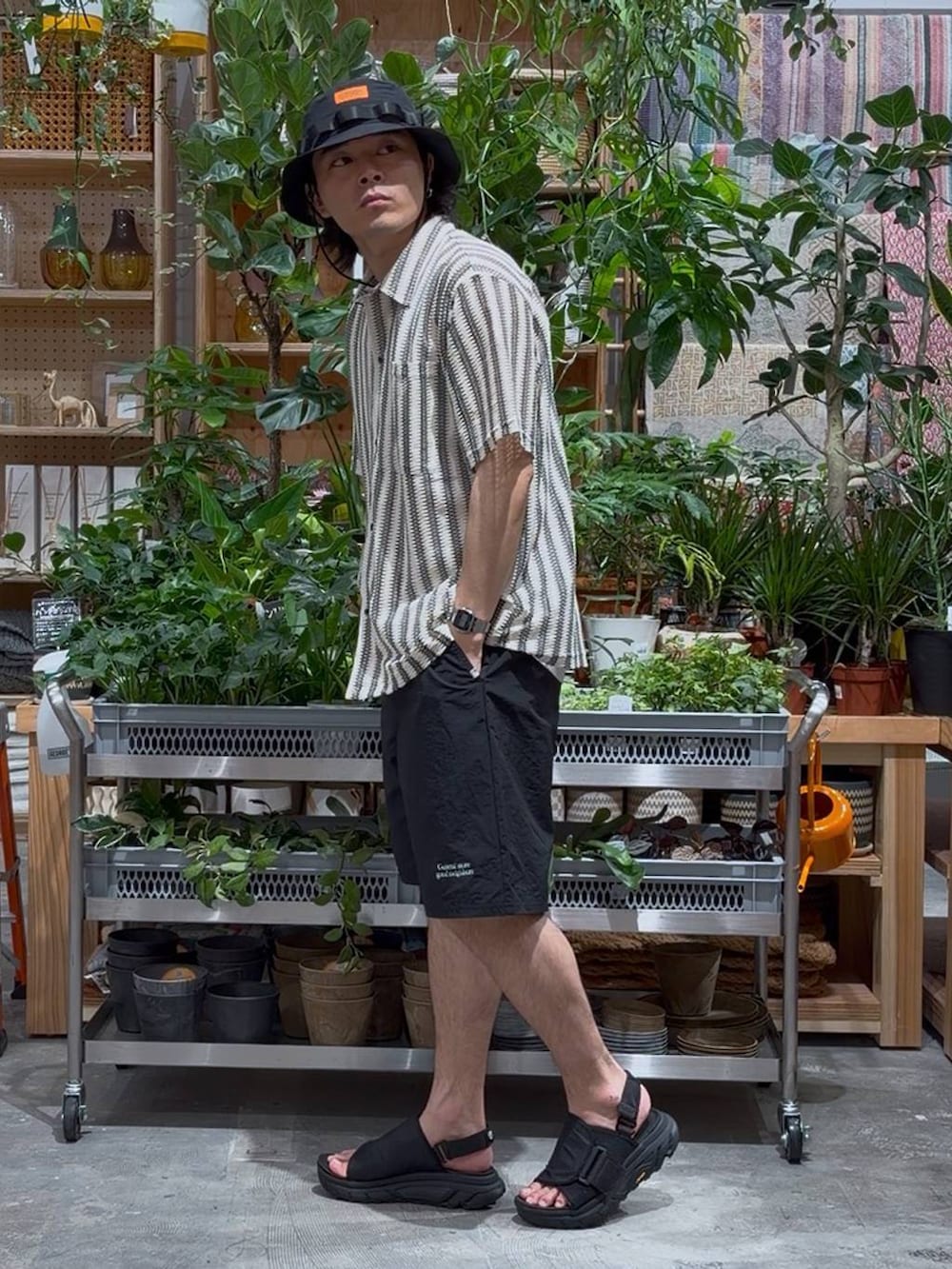 ブラック系のサンダル、ブラック系のその他パンツ、ホワイト系のタンクトップを着用したメンズの春コーディネートの3枚目の写真