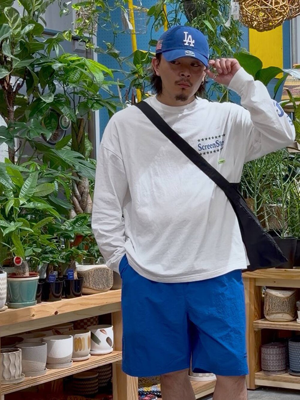 ブラック系のエコバッグ/サブバッグ、ホワイト系のTシャツ/カットソー、ブルー系のその他パンツを着用したメンズの春コーディネートの5枚目の写真