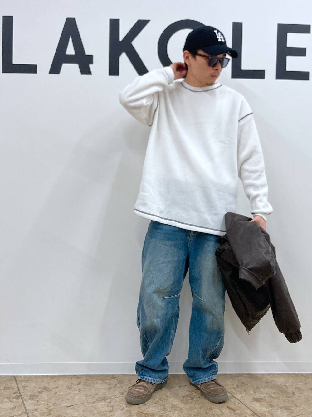 ブルー系のデニムパンツ、ホワイト系のTシャツ/カットソー、ブラウン系のブルゾンを着用したメンズの秋コーディネートの4枚目の写真