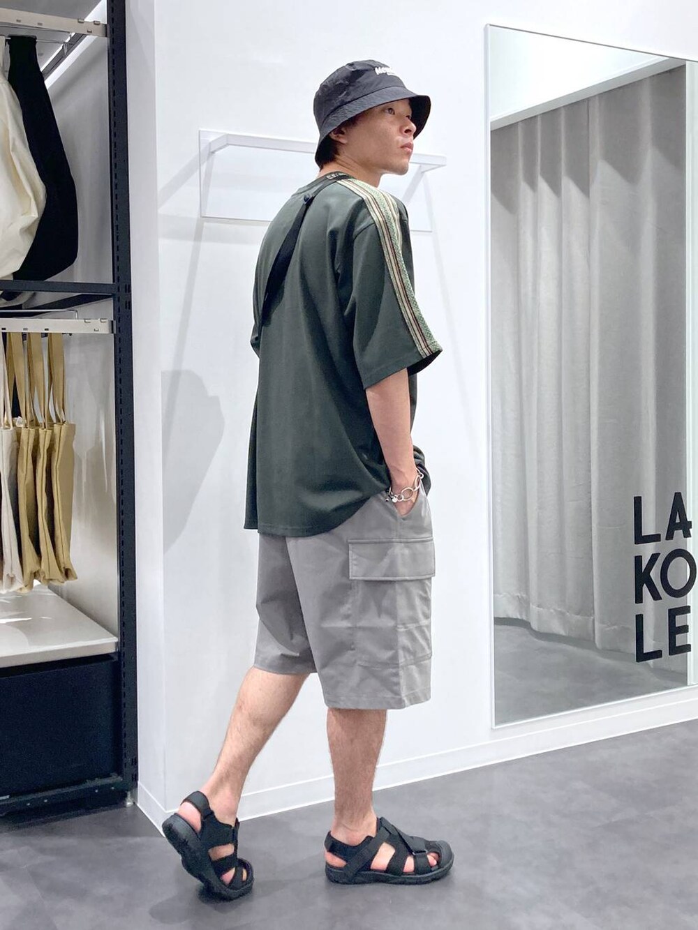ブラック系のショルダーバッグ、ブラック系のサンダル、グリーン系のTシャツ/カットソーを着用したメンズの夏コーディネートの4枚目の写真