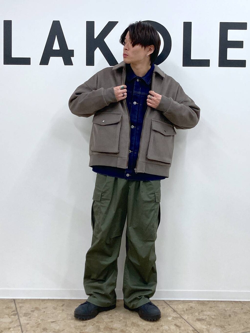 グリーン系のカーゴパンツ、ブラウン系のブルゾン、ブルー系のデニムジャケットを着用したメンズの冬コーディネートの4枚目の写真