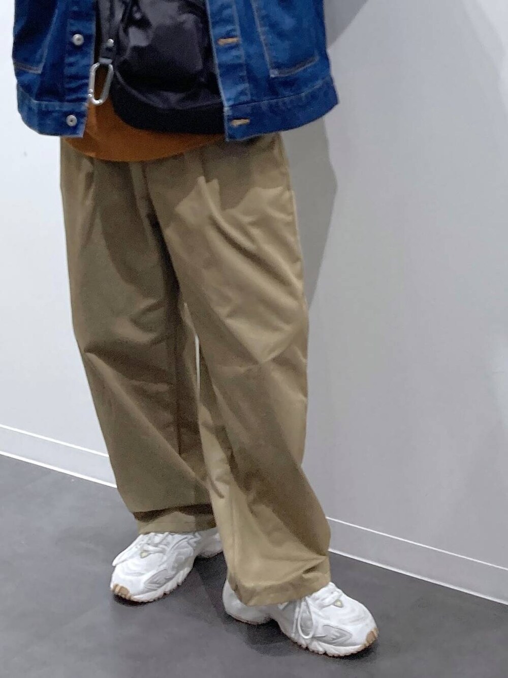 ブラック系のボディバッグ/ウエストポーチ、ホワイト系のスニーカー、ブルー系のデニムジャケットを着用したメンズの秋コーディネートの9枚目の写真