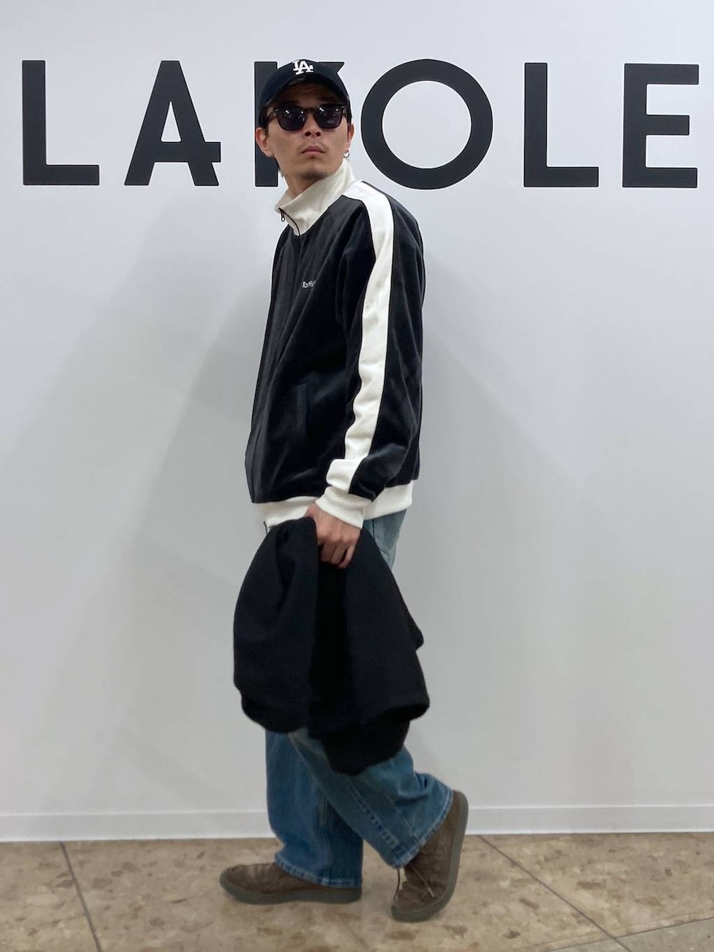 ブラック系のテーラードジャケット、ブルー系のデニムパンツ、ブラック系のその他アウターを着用したメンズの秋コーディネートの7枚目の写真